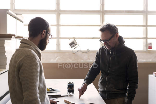Carpinteiro conversando com o cliente em oficina — Fotografia de Stock