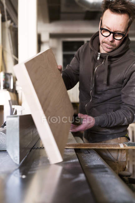 Carpenter holding wooden plank — Stock Photo