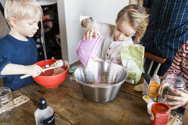Crianças misturando ingredientes de pão na tigela — Fotografia de Stock