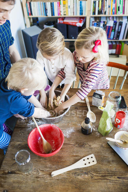 Pai feliz com crianças misturando ingredientes — Fotografia de Stock