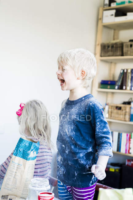 Menino brincando com farinha e assando com a irmã — Fotografia de Stock
