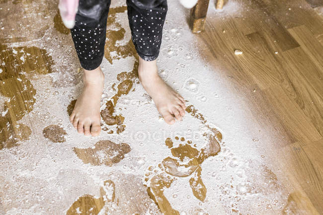 Menina de pé no chão coberto de farinha — Fotografia de Stock