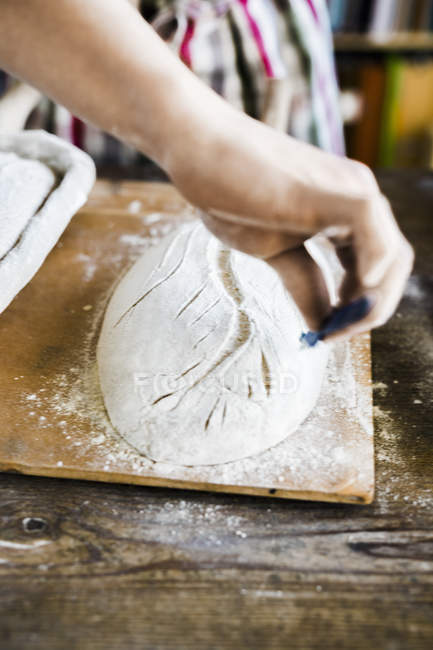 Panaderos manos haciendo diseño en la masa - foto de stock