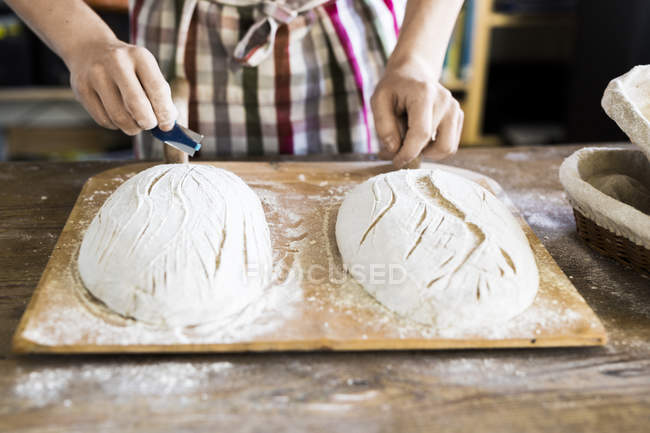 Boulanger faisant la conception sur la pâte — Photo de stock