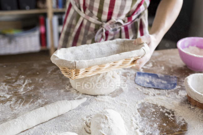 Bäcker hält Korb am Tisch — Stockfoto