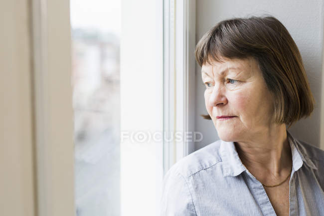 Mujer de negocios sentada en el alféizar de la ventana - foto de stock