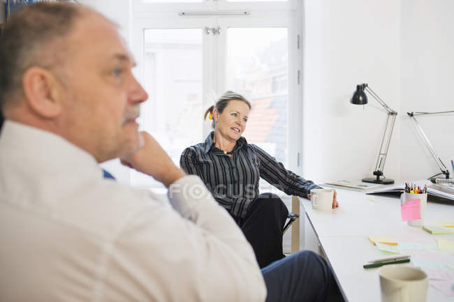 Business people sitting at desk in office — Stock Photo