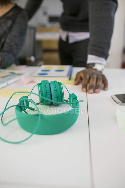 Headphones and business people in background — Stock Photo