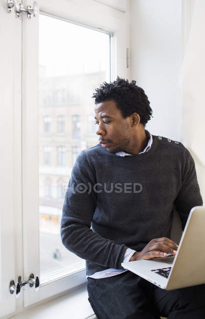 Retrato de empresário afro-americano com laptop — Fotografia de Stock