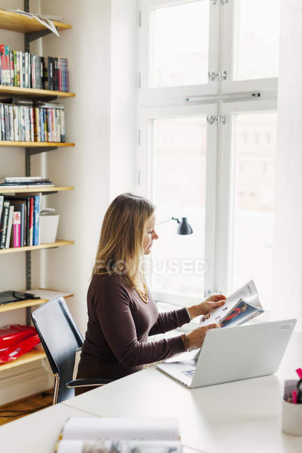 Зрелая деловая женщина читает журнал — стоковое фото