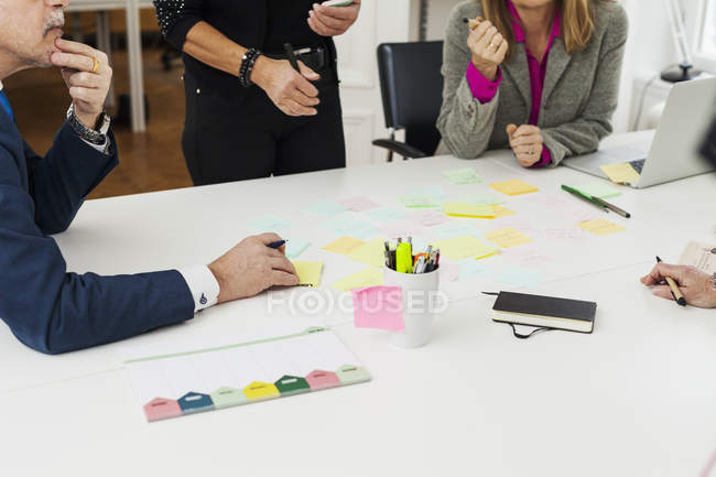 Businesspeople discussing over adhesive notes — Stock Photo