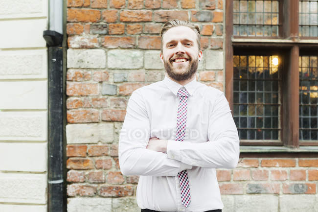 Confident businessman standing arms crossed — Stock Photo