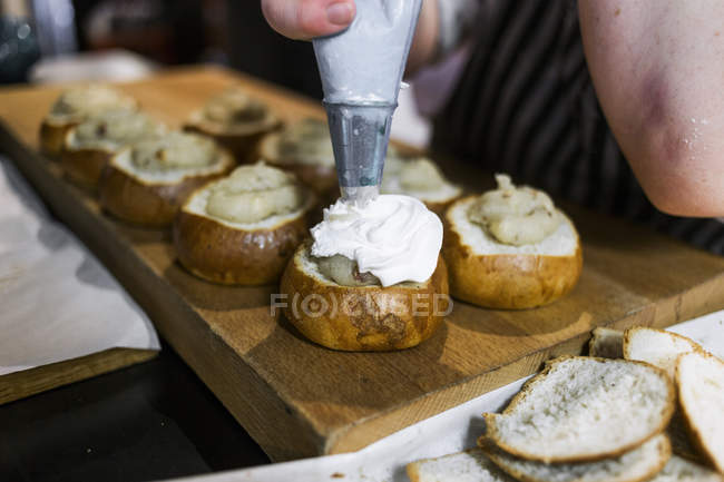 Chef glaçage petits pains dans la cuisine — Photo de stock