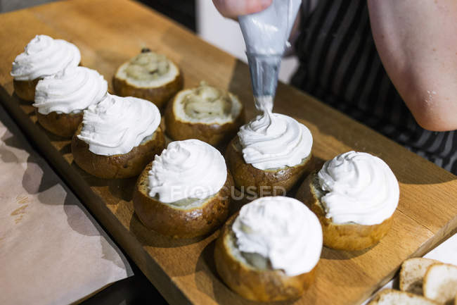 Chef icing buns in kitchen — Stock Photo