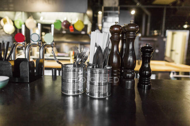 Pepper grinders and cutlery — Stock Photo