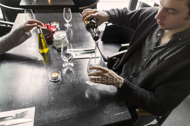 Homem derramando água em copo de vinho — Fotografia de Stock