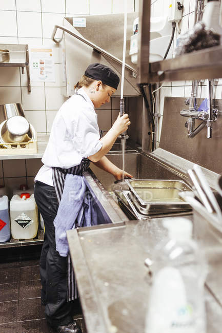 Chef lave-ustensile dans la cuisine commerciale — Photo de stock