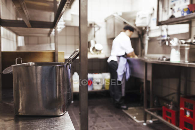 Шеф-повар работает на коммерческой кухне — стоковое фото