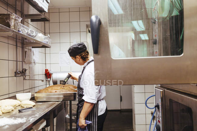 Chef checking temperature of bread — Stock Photo