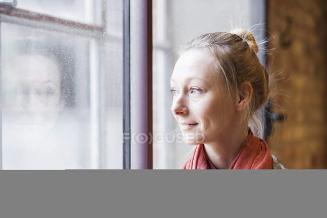 Woman looking through window in cafe — Stock Photo