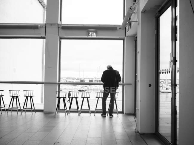 Чоловік стоїть перед вікном — стокове фото