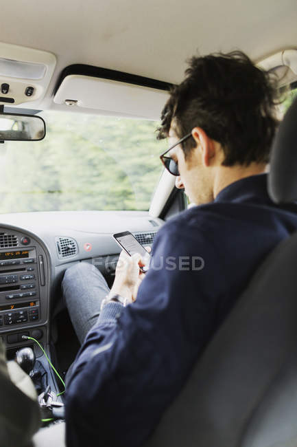 Homem usando telefone inteligente no carro — Fotografia de Stock