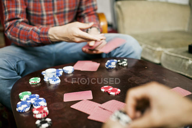 Deux hommes jouent aux cartes à la maison — Photo de stock