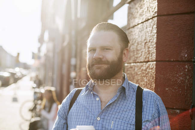 Uomo sorridente sul marciapiede — Foto stock
