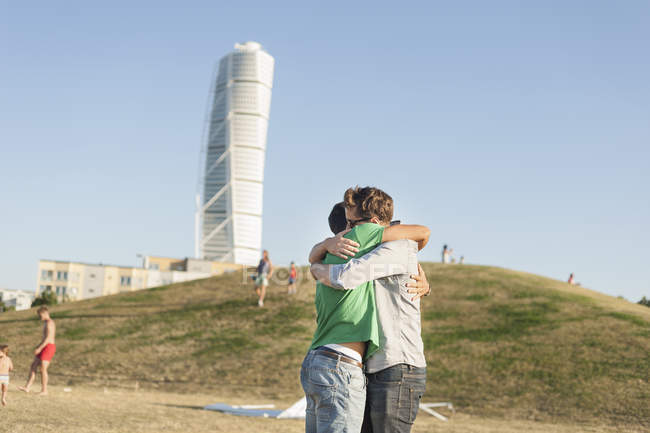 Freunde umarmen sich auf dem Feld — Stockfoto