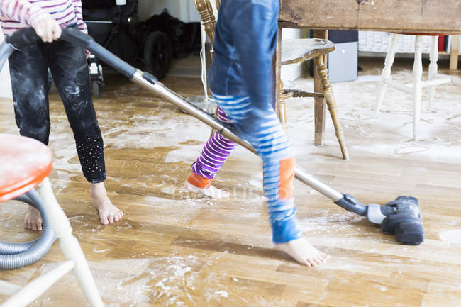 Kids cleaning up mess after baking — Stock Photo