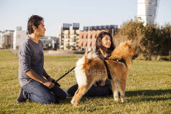 Casal com cão relaxante — Fotografia de Stock