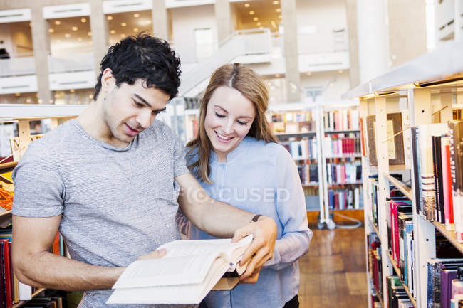 Young friends reading book — Stock Photo