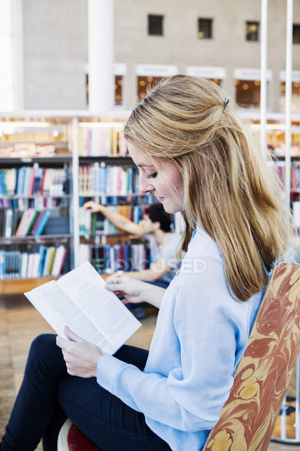 Mujer joven leyendo libro - foto de stock