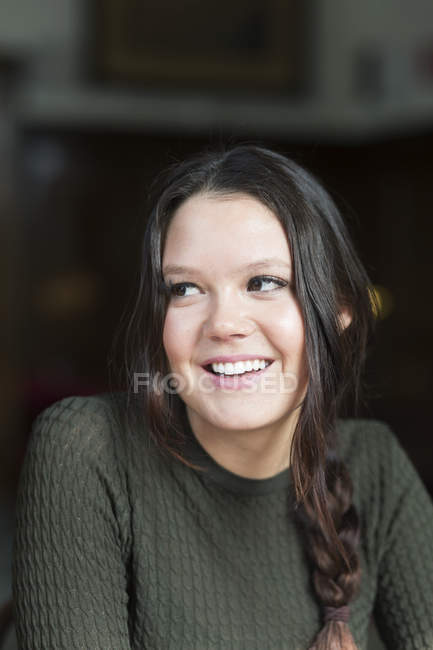 Mujer sonriendo mientras mira hacia otro lado - foto de stock
