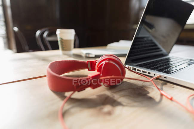 Червоні навушники та ноутбук — стокове фото