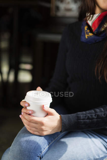 Jovem mulher segurando café descartável — Fotografia de Stock