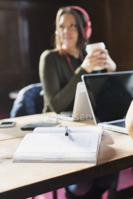 Book on table with student — Stock Photo