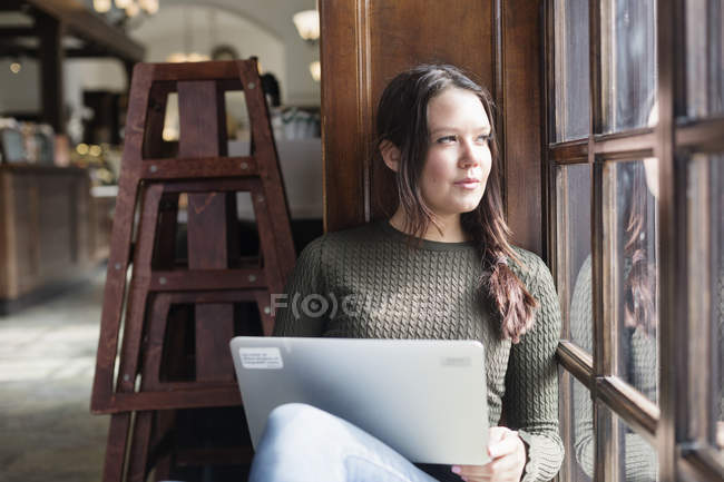 Молода жінка тримає ноутбук — стокове фото