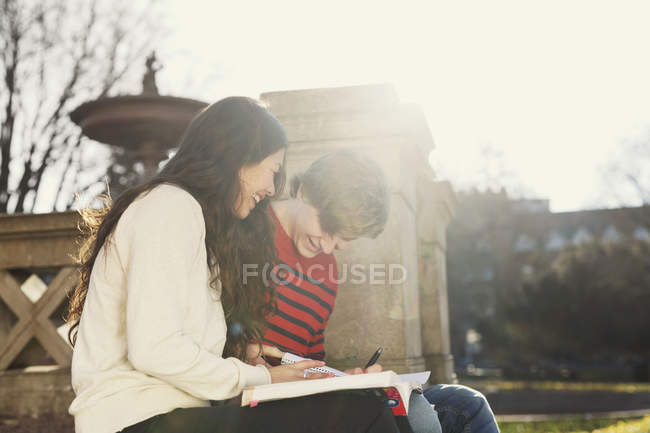 Estudiantes universitarios sonrientes leyendo libro - foto de stock