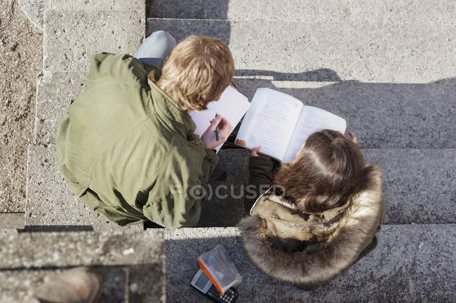 Teenage boy and girl reading book — Stock Photo