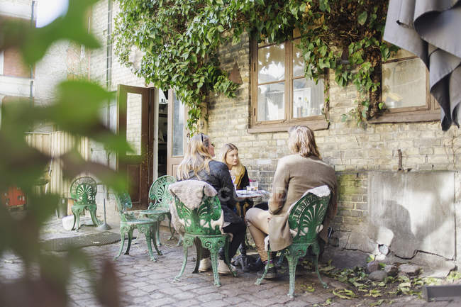 Amis assis au restaurant extérieur — Photo de stock