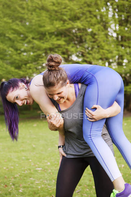 Woman carrying female friend — Stock Photo