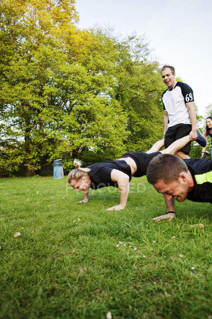 People exercising on grassy field — Stock Photo