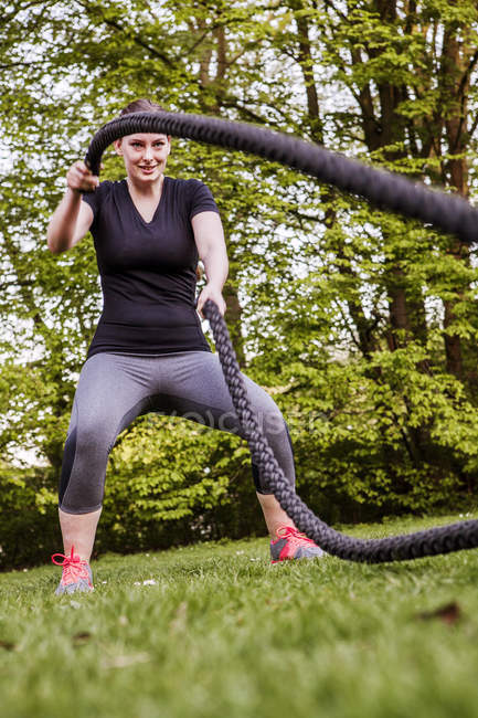 Жінка робить тренування мотузки в парку — стокове фото