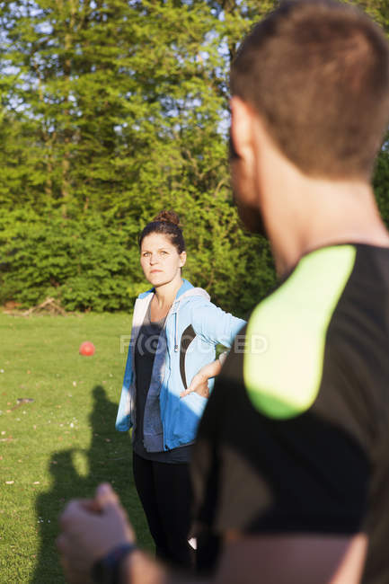 Man and woman standing on grassy field — Stock Photo