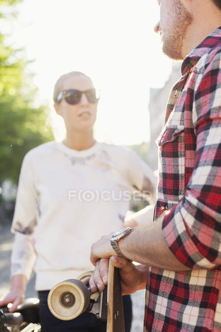 Friends with skateboard standing on street — Stock Photo