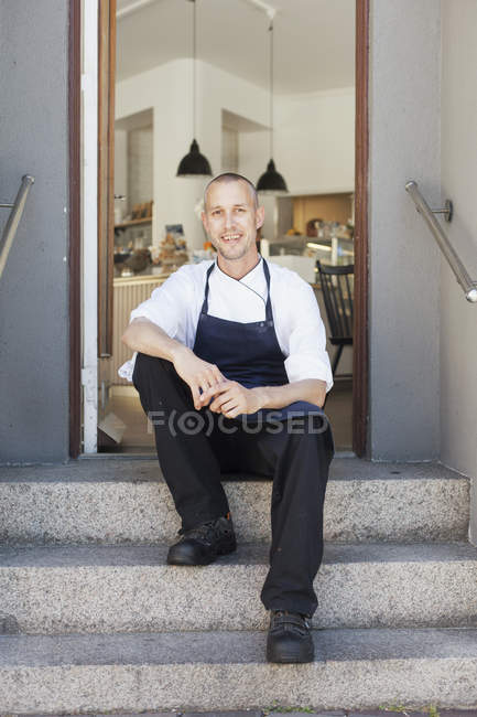 Feliz proprietário masculino sentado em passos — Fotografia de Stock