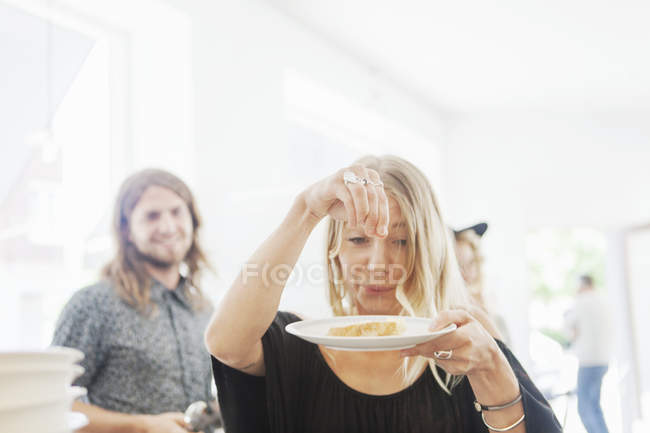 Playful woman sprinkling salt on bread — Stock Photo