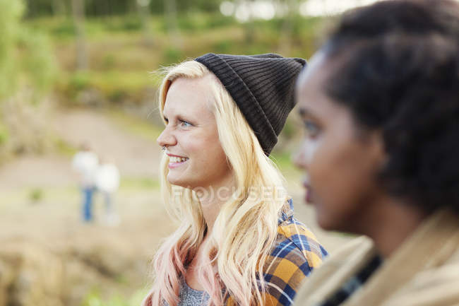 Усміхнена жінка стоїть з другом на відкритому повітрі — стокове фото