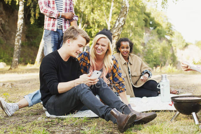 Happy friends using mobile phone — Stock Photo